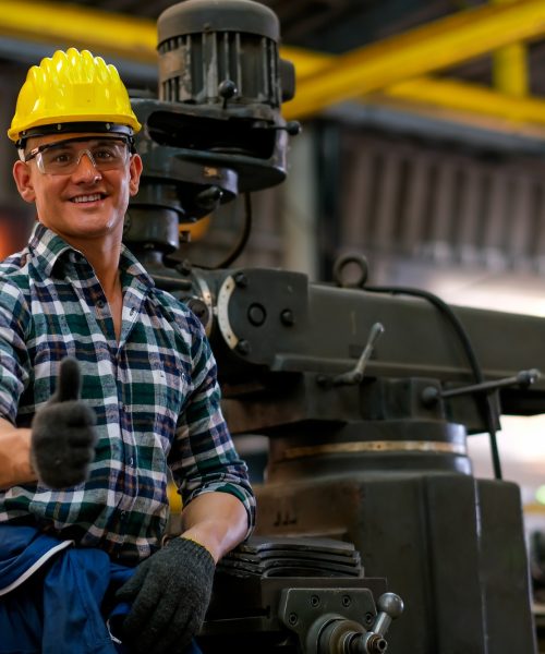 Front view of smart technician or engineer worker with protective helmet stand with confident